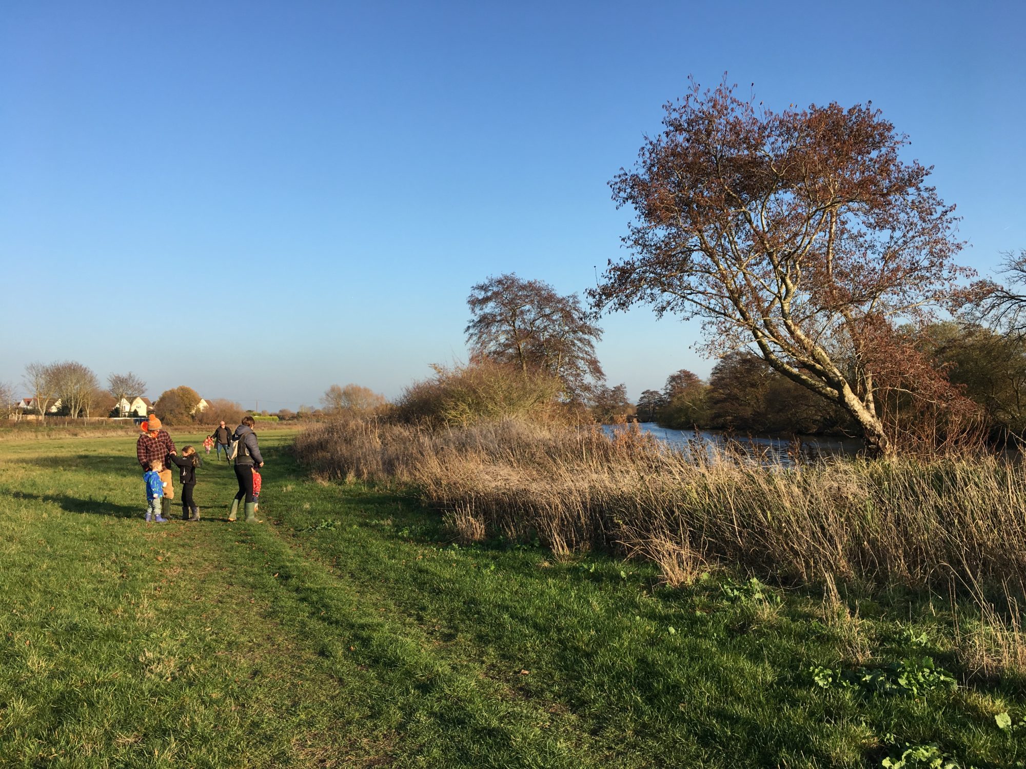 A group of people walking by the River Thames at Dorchester