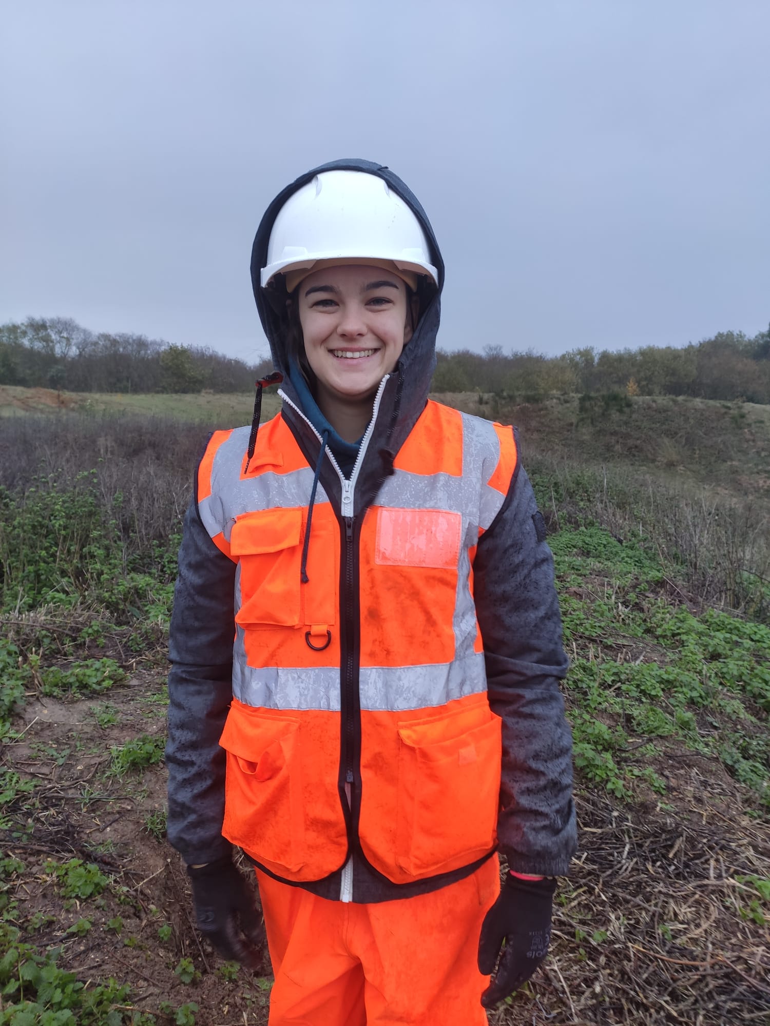 A Bioscan (UK) Ltd employee, Emily Day, stands facing the camera in full high-visibility protective gear.